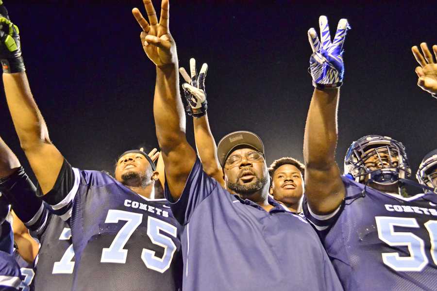 Coach Alonzo Carter (center) points toward their conference banner in the stands after the Comets’ 51- 10 win over San Jose City College at Comet Stadium on Saturday, Nov. 15, 2014.  The win clinched the  team’s third  consecutive conference championship.