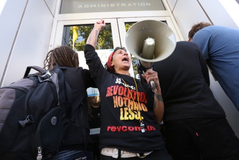 Maya Malika, a member of the Revolutionary Communist Party, shouts in front of the Oakland Police Department on 7th Street during the Shut Down Day rally in Oakland on April 14.