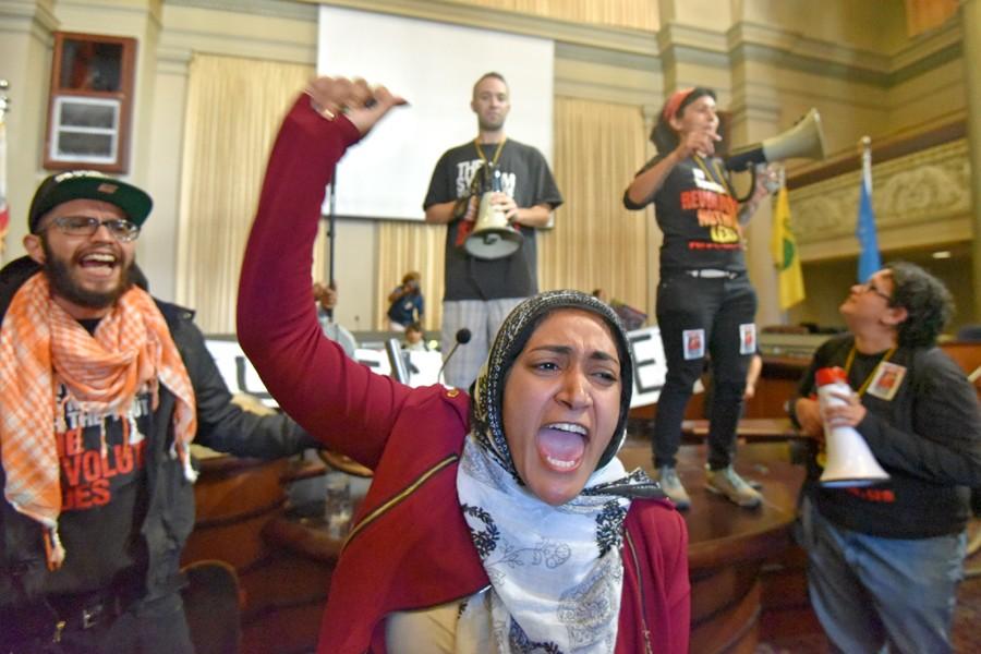 Alameda resident Sarah K. chants with protesters inside the Oakland City Council Chambers during the first stop of the Shut Down Day rally in Oakland on April 14.
The protest was organized to raise awareness about the increase of police officers using lethal force.