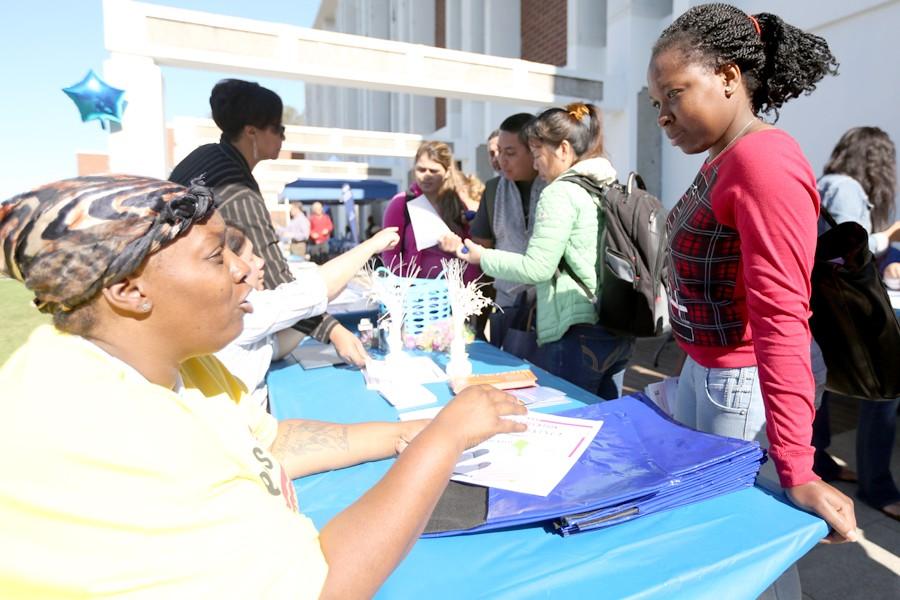 Inter-Club Council President Safi Ward-Davis speaks to a student about different services available locally during the Wellness Day event on the patio in front of the Liberal Arts Building on March 25.