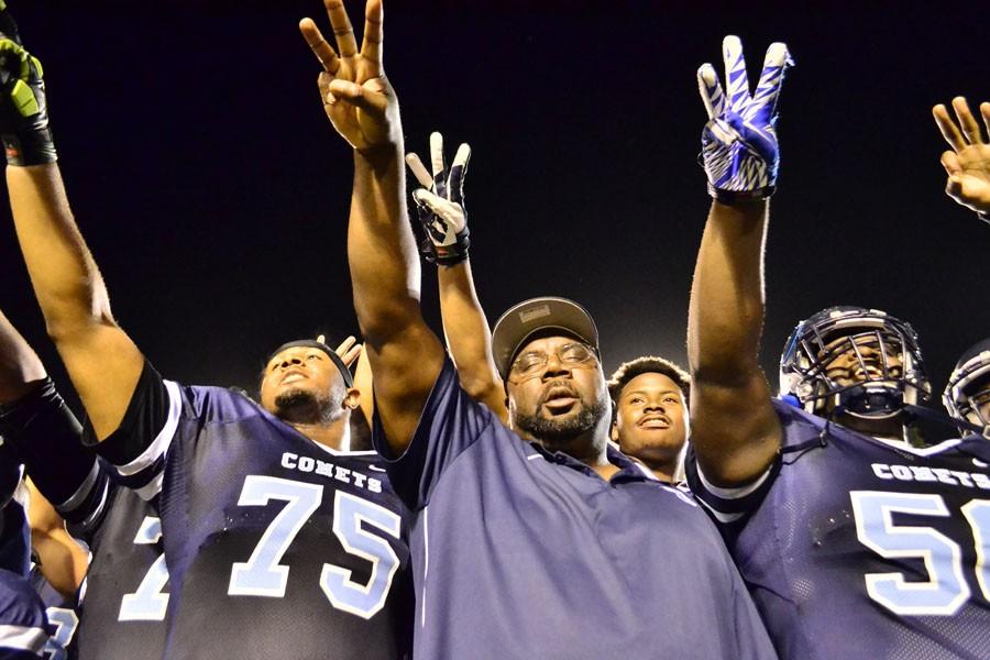 Coach Alonzo Cater (center) points toward the team’s championship banner in the stands after the Comets’ 51-10 win over San Jose City College at Comet Stadium on Nov. 15, 2014. The win clinched the team’s third consecutive conference championship.