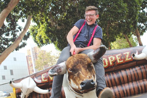 Oakland resident Ian Anderson rides a mechanical bull from the Eventos Lopez company during the 6th annual Oakland Pride and Parade Festival at 20th Street and Broadway on Sunday.