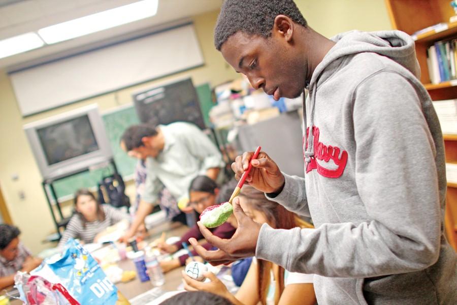 Computer engineering major Ogheneyengbame Akpojiyoubui paints a paper maché skull for La Raza Club’s planned Day of the Dead event during its meeting on Oct. 16 2014.