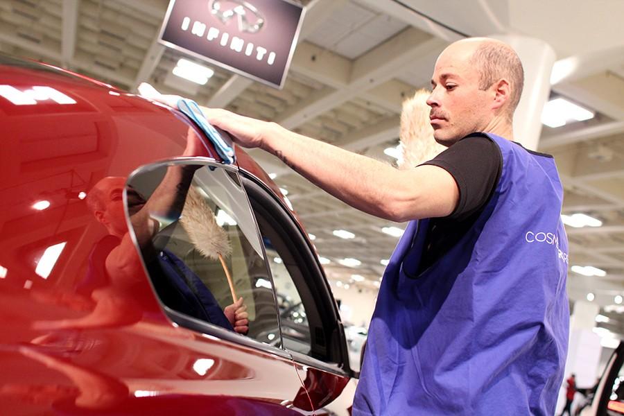 Cosmetic Car Care employee Zach Lyle wipes off the fingerprints of attendees on an Infiniti Q60 coupe during the 2015 San Francisco International Auto Show at the Moscone Center on Nov. 26. Lyle and other employees were responsible for the  maintenance and visual aesthetics of the models on the show floor.       