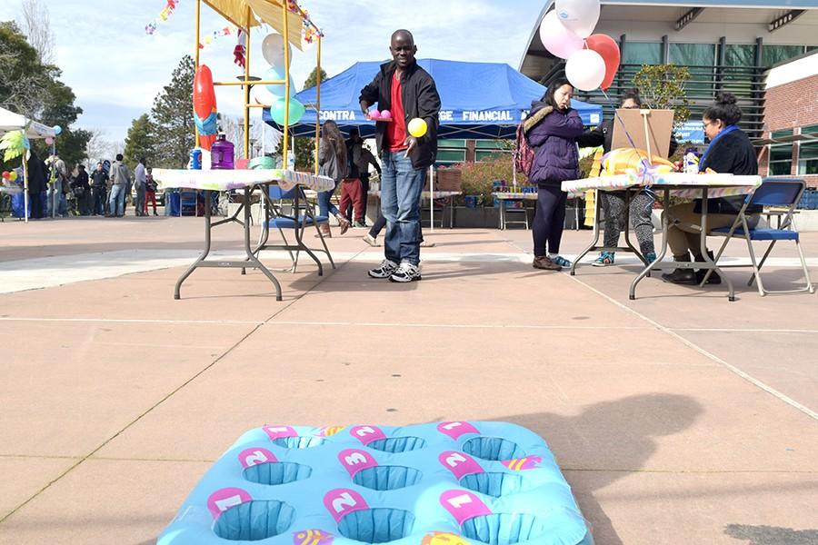 Nicholas Kavuina plays the Go Fish Toss in one of the game booths that were part of Financial Aid Awareness Day event held outside of the Student Service Center on February 3, 2016.