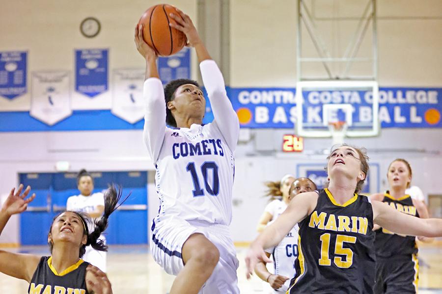 Comet guard Jacqie Moody goes up for a layup against Mariners guard Janelle Pansoy and foward Christiana Onwuasoeze during Contra Costa Colleges 80-57 win against College of Marin in the Gymnasium on Friday.