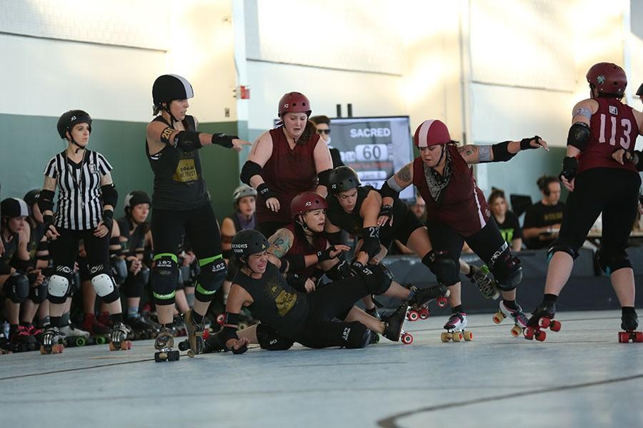 Shengis Khan (lower center) takes a spill during the B.A.D United Double Header at the Craneway Pavilion on Saturday. The skaters wear full body protection with falls being a regular occurrence and pushing, shoving and blocking being the main strategy of the game.