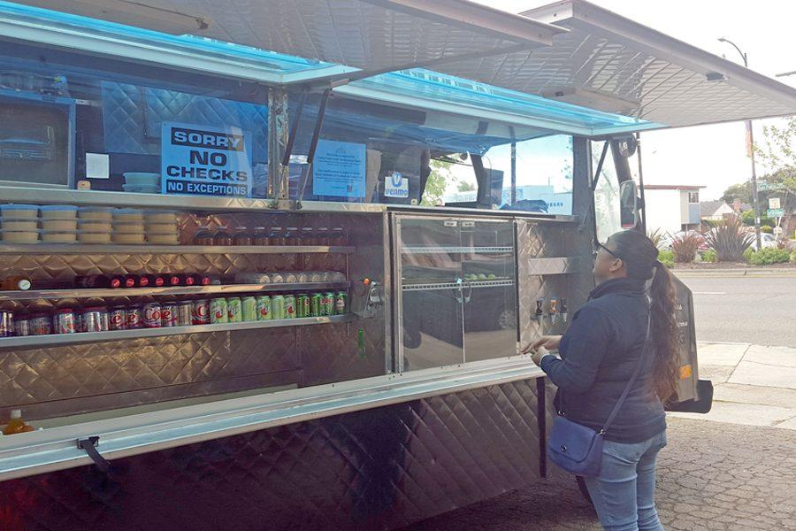 An El Cerrito resident places an order at Curbside Kitchen, outside of Barney McBears, on April 10. The food truck is parked next to the bar every Sunday. 