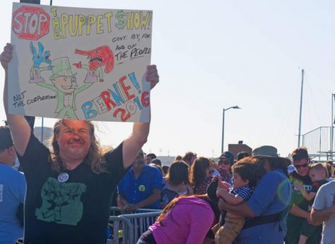 A Sen. Bernie Sanders supporter holds up a sign that exposes the corruption of both the democratic and republican parties at a presidential primary rally at the Waterfront Park in Vallejo, Calif. on Wednesday, May 18.