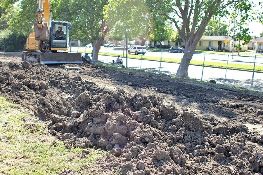 Workers pack dirt into place by the Tennis Courts after Kleinfelder Inc. geologists checked the area for evidence of seismic activity on Wednesday.