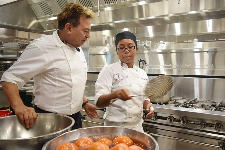Culinary arts Chairperson Nader Sharkes and student Kyle DeLos Santos
submerge hot tomatoes under cool water in the Student and Administration Building on Friday.