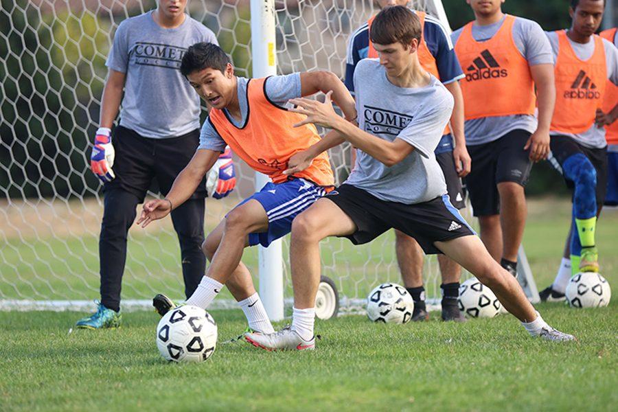 Comet soccer players fight for possession of the ball during a defensive one-on-one drill during practice at the Soccer Field on Monday.