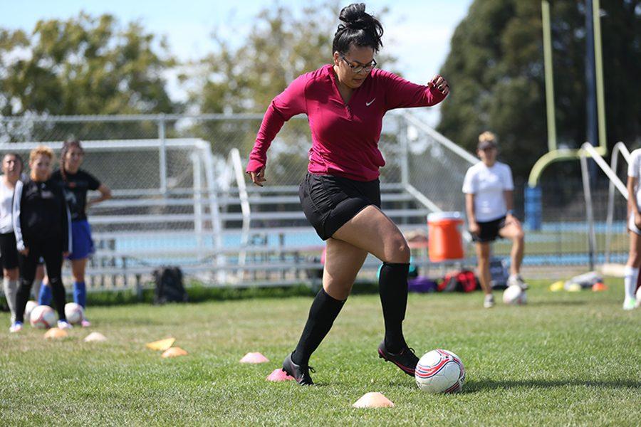 Administration of justice major Ingrid Gonzalez dribbles through cones during soccer practice at the Soccer Field on Monday.