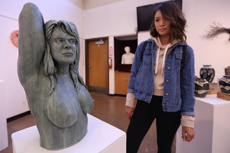 Health and human services major Carolyn Tran surveys a sculpture by CCC alumnus C.E. Small in the Eddie Rhodes Gallery on Thursday. 