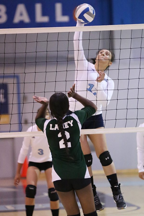 Comet outside hitter Alejandra Galvez spikes the ball over Eagle middle blocker Da’ja Archer during CCC’s 3-0 win over Laney College in the Gymnasium on Sept. 20. 