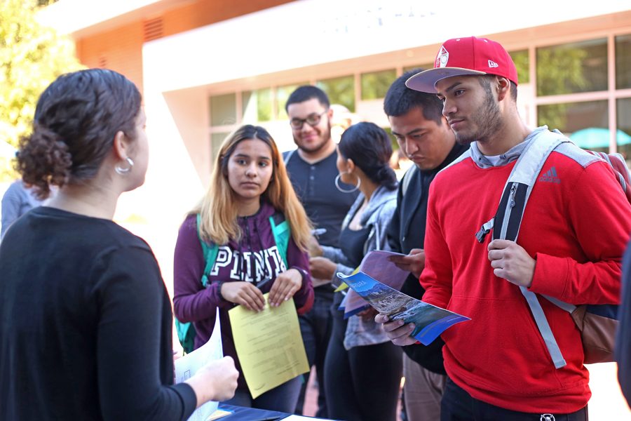 Engineering major Robert Garcia speaks with Cal State-San Bernardino representative Adra Bowman during the College Day event in the Campus Center Plaza on Tuesday.
