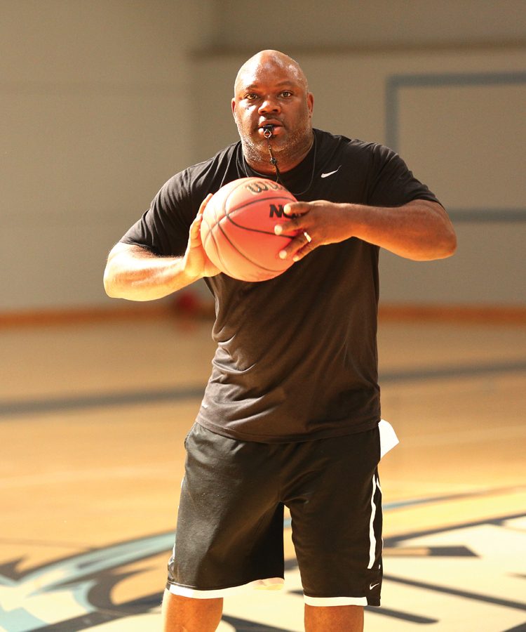 Women’s basketball coach Vince Shaw passes the ball to a player during a practice drill in the Gymnasium on Thursday.