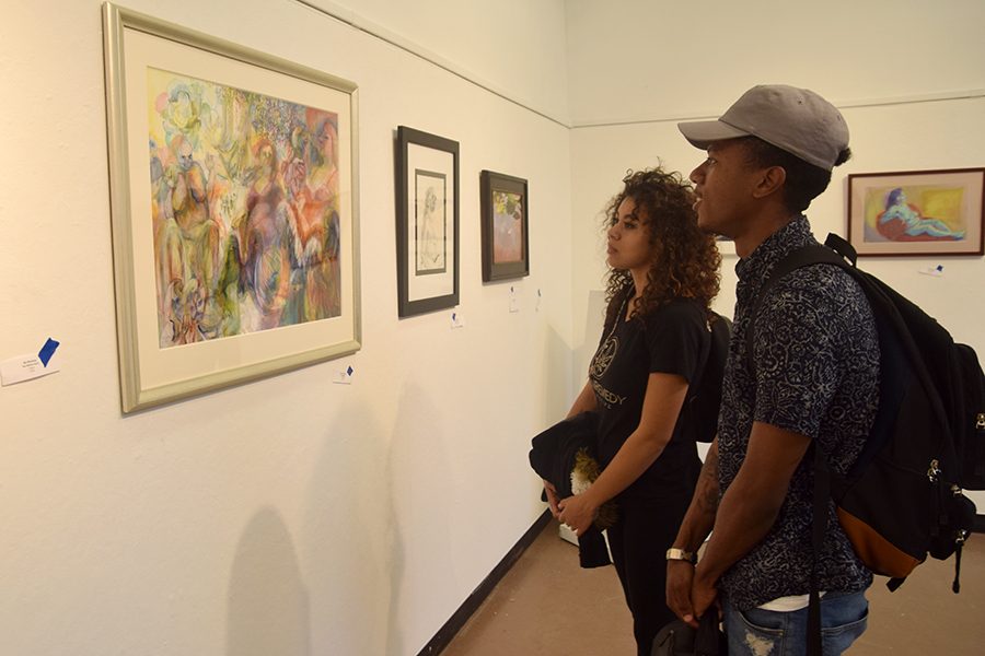 Business major Clarence Bonilla (right) and undecided major Christina Hantakas observe pieces of art in the Eddie Rhodes Gallery as part of the “Ageless Expression” exhibit in A-5 on Oct. 11. 
