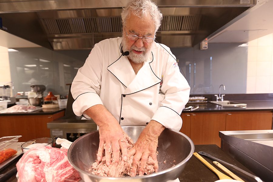 Culinary chef and author Bruce Aidells churns his chorizo recipe during the guest chef event in the culinary arts department’s demonstration kitchen in the Student and Administration Building on Friday.