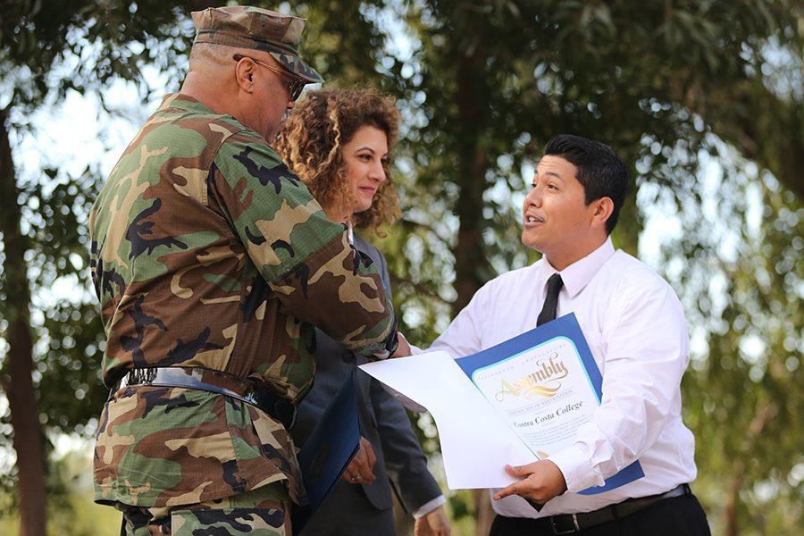 The Armed Services Support Group President Leon Watkins (left) and President Mojdeh Mehdizadeh (middle) receive a letter of appreciation from District 15 Assembly member Tony Thurmonds representative during the opening ceremony of the Veterans Resource Center in the Amphitheater on Thursday.