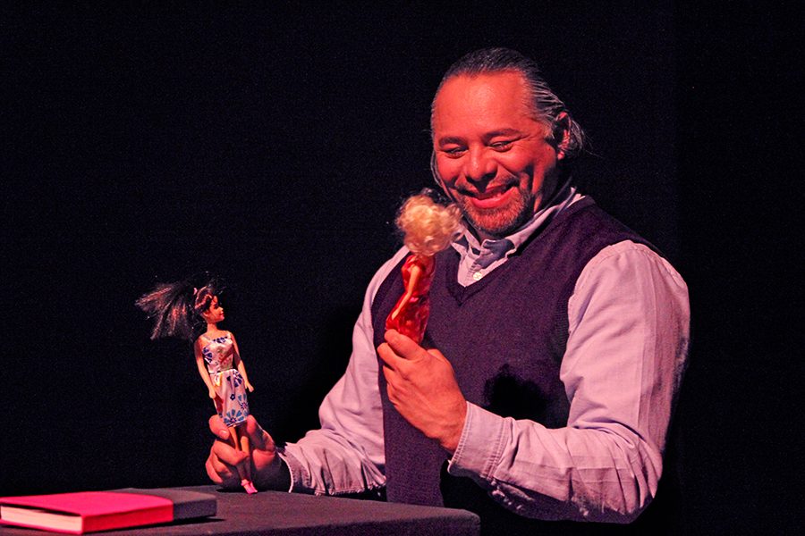 Drama department Chairperson Carlos-Manuel Chavarría plays with two dolls during a scene of the one person play, “Joto!: Confessions of a Mexican Outcast,” in Knox Center on Friday. 