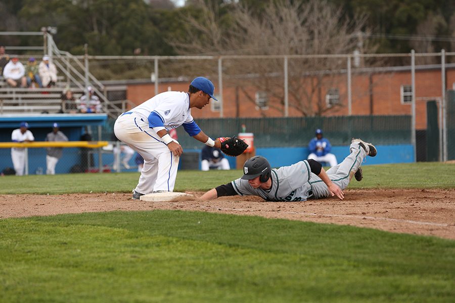 Saint outfielder Tyler Barry slide back into first before the tag by Comet first baseman Eric Whitfield during CCCs 6-2 loss to Mission College at the Baseball Field on Sunday.