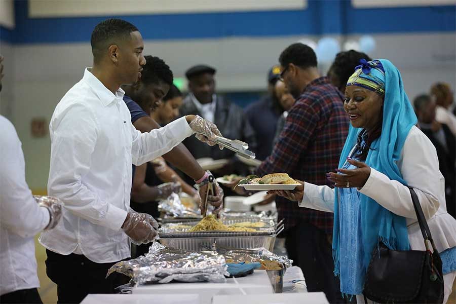cody casares / The Advocate
Liberal arts major Troy Hearne fills West Contra Costa Unified School District sixth grade teacher Verdell Simon-Tatum’s plate during the annual all you can eat Crab Feed event in the Gymnasium on Saturday. The fundraiser encourages attendees to feast on crabs, pasta and bread.
