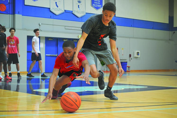 Bishop O’Dowd High School (Oakland) freshman Ryzon Norris (left) dives for the ball as another player fights him for it during the NorCal Future bas- ketball camp in the Gymnasium on Sunday.