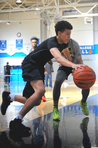 High school basketball player dribbles past an opponent during the NorCal Future bas- ketball camp to begin their day in the Gymnasium on Sunday.