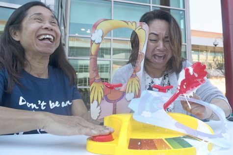 HSI STEM Manager Mayra Padilla (right) and  (left) Center for Science Excellence program Coordinator Seti Sidharta play the game Pie Face Showdown during the Women Advancing Via Engineering and Science (WAVES) club fundraising event in the Student Center Campus on Tuesday.