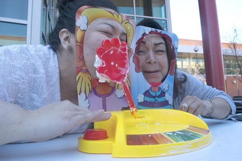 HSI STEM Manager Mayra Padilla (right) and  (left) WAVES club adviser Kelly Ramos play the game Pie Face Showdown during the Women Advancing Via Engineering and Science (WAVES) club fundraising event in the Campus Center Plaza on Tuesday.