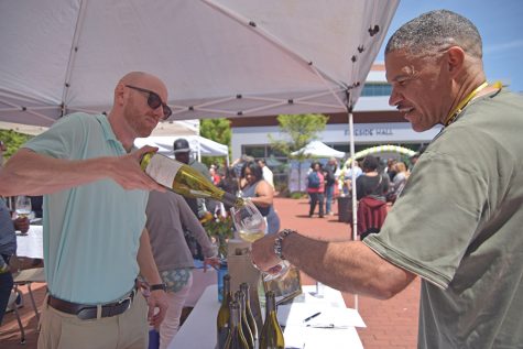 Attune Wine representative Jason Campbell (left) pours Richmond resident Barry Grant a glass of 2015 chardonnay during the Food and Wine Event in the Campus Center Plaza on Sunday.