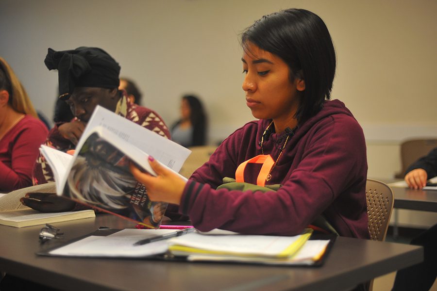 Medical assistant major Diana Lapop flips through pages of the Anthropology of
Religion, Magic and Witchcraft textbook during an Anthropology 150 class session
in GE-311 on Thursday. The class reviewed witchcraft in European villages.