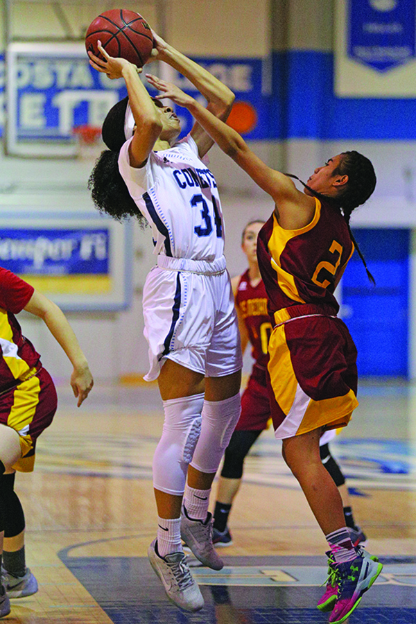 Comet forward Keyauna Harrison goes up for a shot with Mustang guard Margot Vranas hand in her face during CCCs 64-45 win against Los Medanos College in the Gymnasium on Jan. 27.