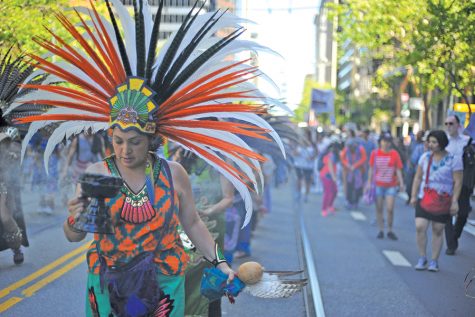 San Francisco resident Maya Ponce performs a traditional Aztec dance during a march from Justin Herman Plaza to Civic Center on May Day in San Francisco on Monday.