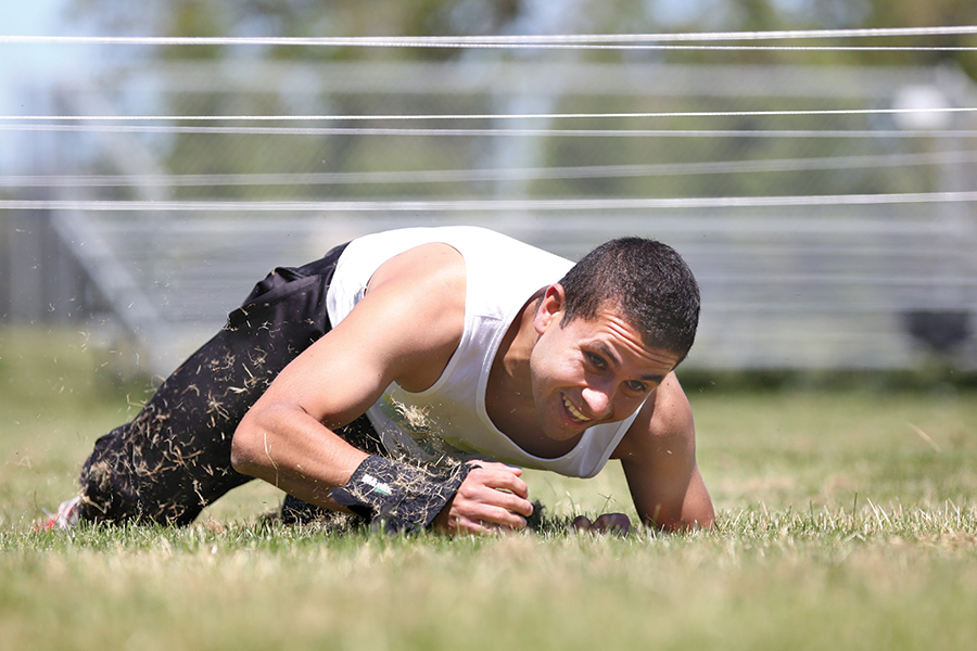 Comet soccer player Eduardo Escamilla crawls under ropes as part of an obstacle course on the Soccer Field during the first Contra Costa College Olympics on Saturday.