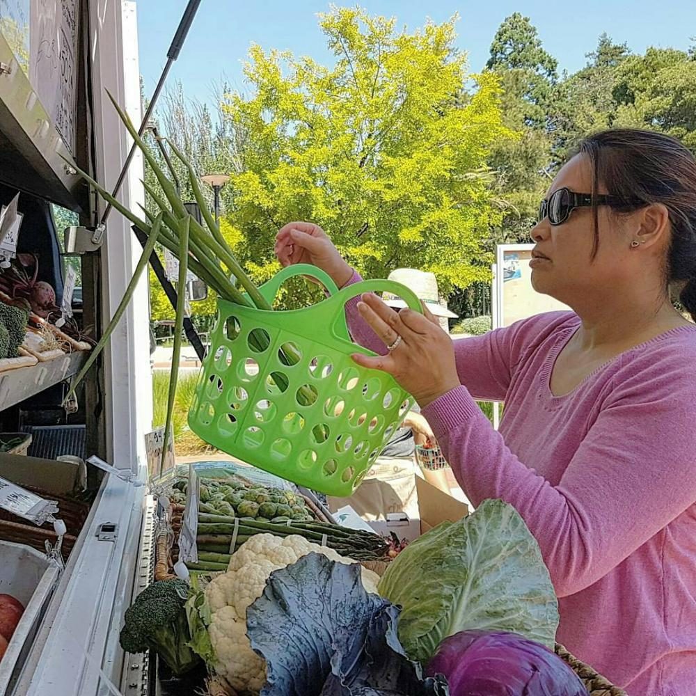 EOPS assistant Chau Tran shops at Fresh Approachs mobile farmers market in the Campus Center Plaza on June 19, 2017. 