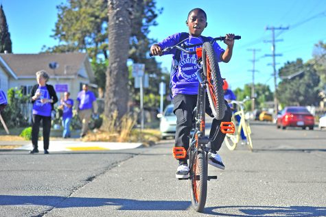 Theodore Tataum performs a wheelie on a bike during the Citywide Walk event hosted by the Richmond Ceasefire in Richmond, Calif on July 21. 