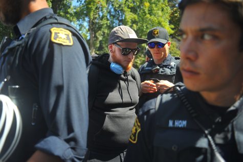A man is arrested for having a mask on inside the police guarded perimeter during the No to Marxism in America rally in Martin Luther King Jr. Civic Center Park in Berkeley, California on August 27. 