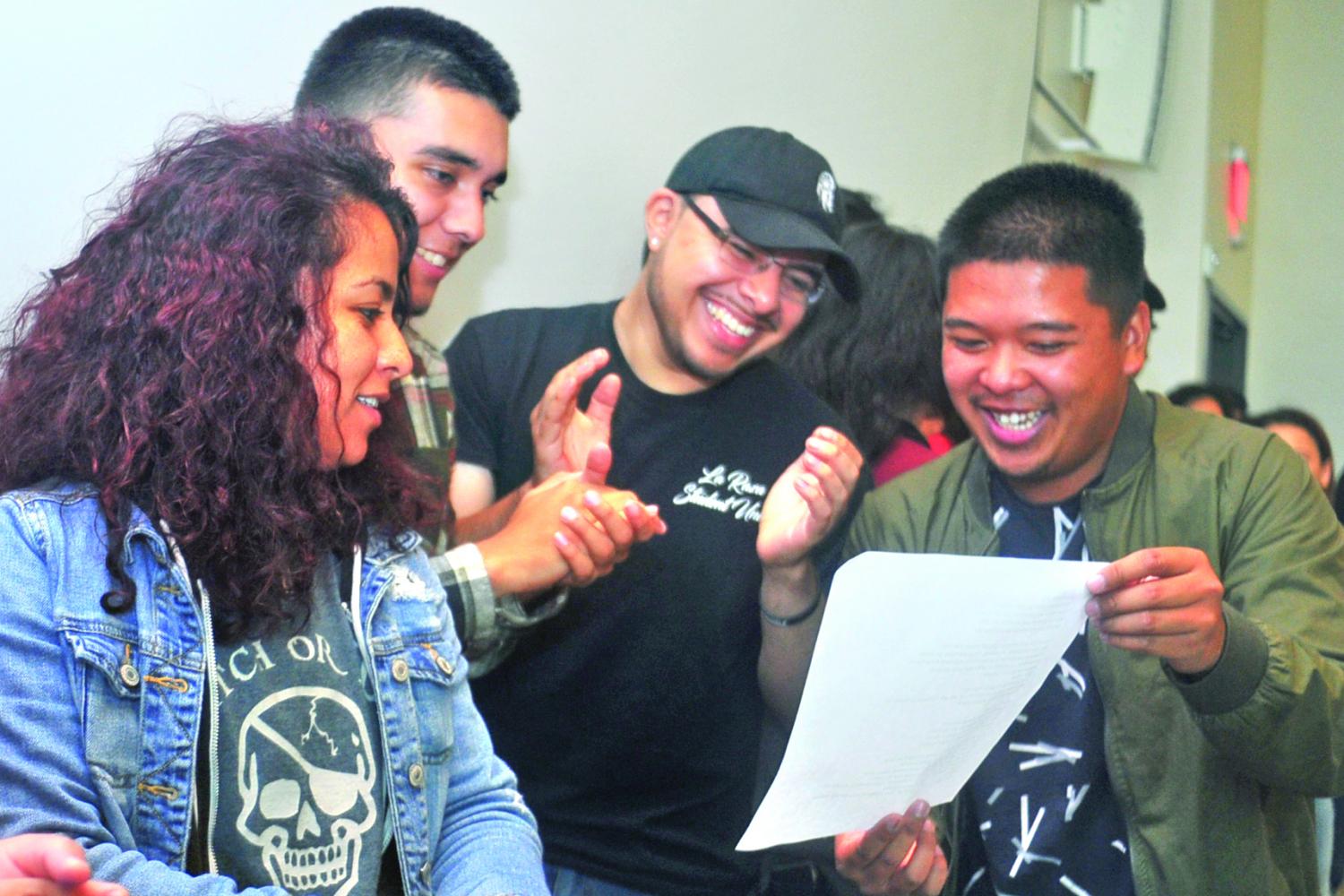 Gabriel Sanchez (middle right) and nursing major Joey Lumagbas (right) join La Raza Student Union and Puente Club members as they read lyrics for a song written by economics major Oscar Martinez during the Deferred Action for Childhood Arrivals, DACA, Info Night in the GE-225 on Friday. 