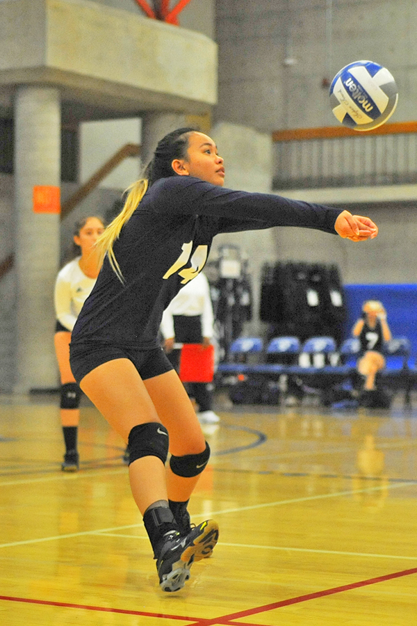 Comet outside hitter Victoria Matue digs the ball over the net during a game against College of Alameda.