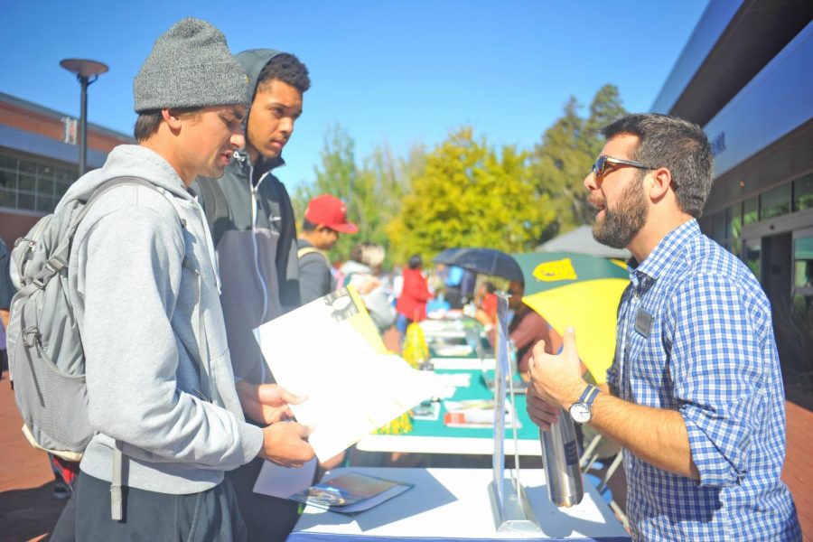 Two students talk with a university representative during Transfer Day on Oct. 3.