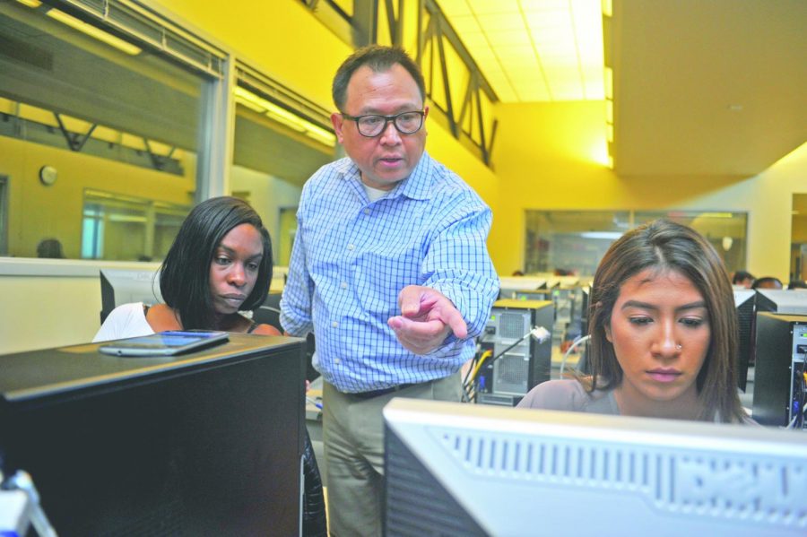 Computer science professor Francis Reyes (middle) guides nursing major Latonya Thomas (left) and undecided major Crystal Morales (right) through a computer science lecture in CTC-115 on Nov. 6. 