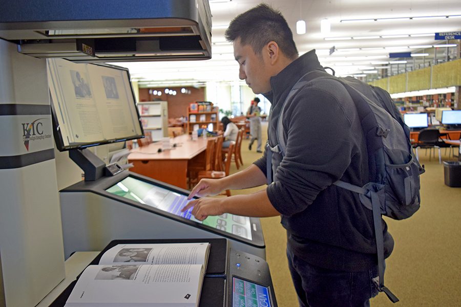 Sociology major Alfred Machacon scans a fibro- myalgia book on Thursday with the free scanner available for student use in the Library.