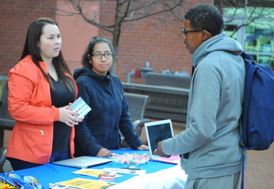 Psychology major Lizbeth Gonzalez (left) speaks to communications major Lionel Harris (right) about Students For Educational Reform during a tabling and informational meeting in the College Center Plaza on Monday.