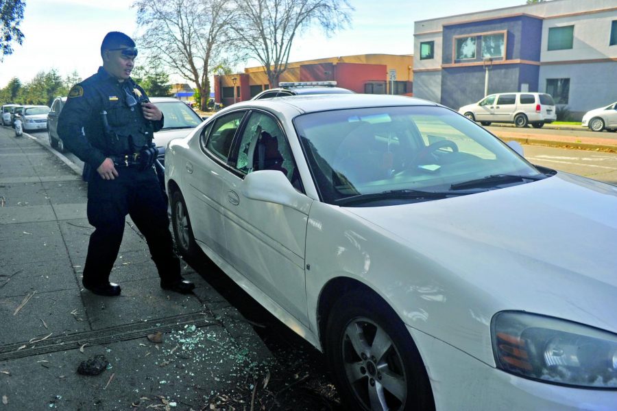 Contra Costa
County Sheriff Deputy  Zunio 
inspects  
nursing major April Flanagan’s car passenger window after it was shattered by a rock on Mission Bell Drive on Jan. 31.
