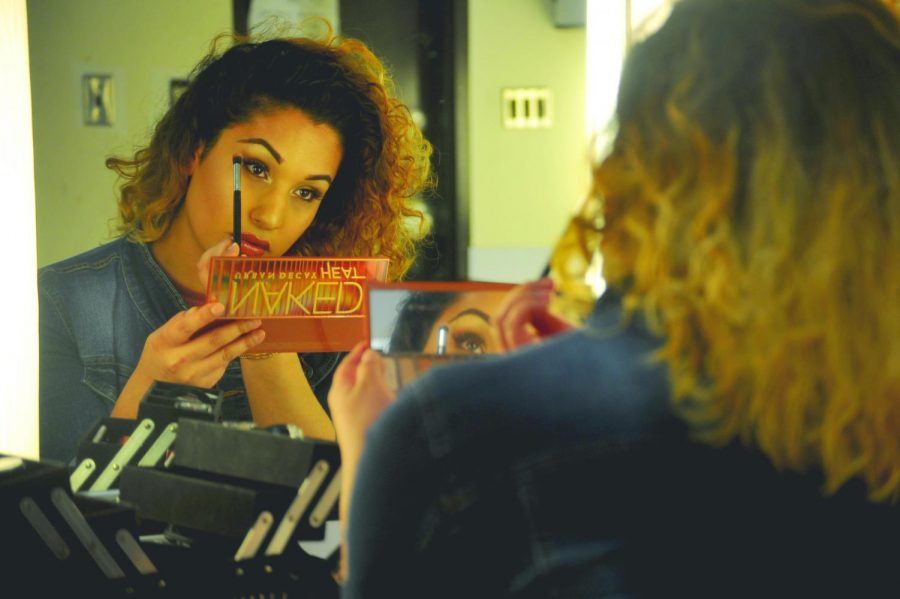 Nursing major Gianna Serrano, formerly known as Bryan Serrano, touches up her eye shadow on 
Friday. Serrano
has been transitioning from a gay cis man to a transgender woman since 2016.