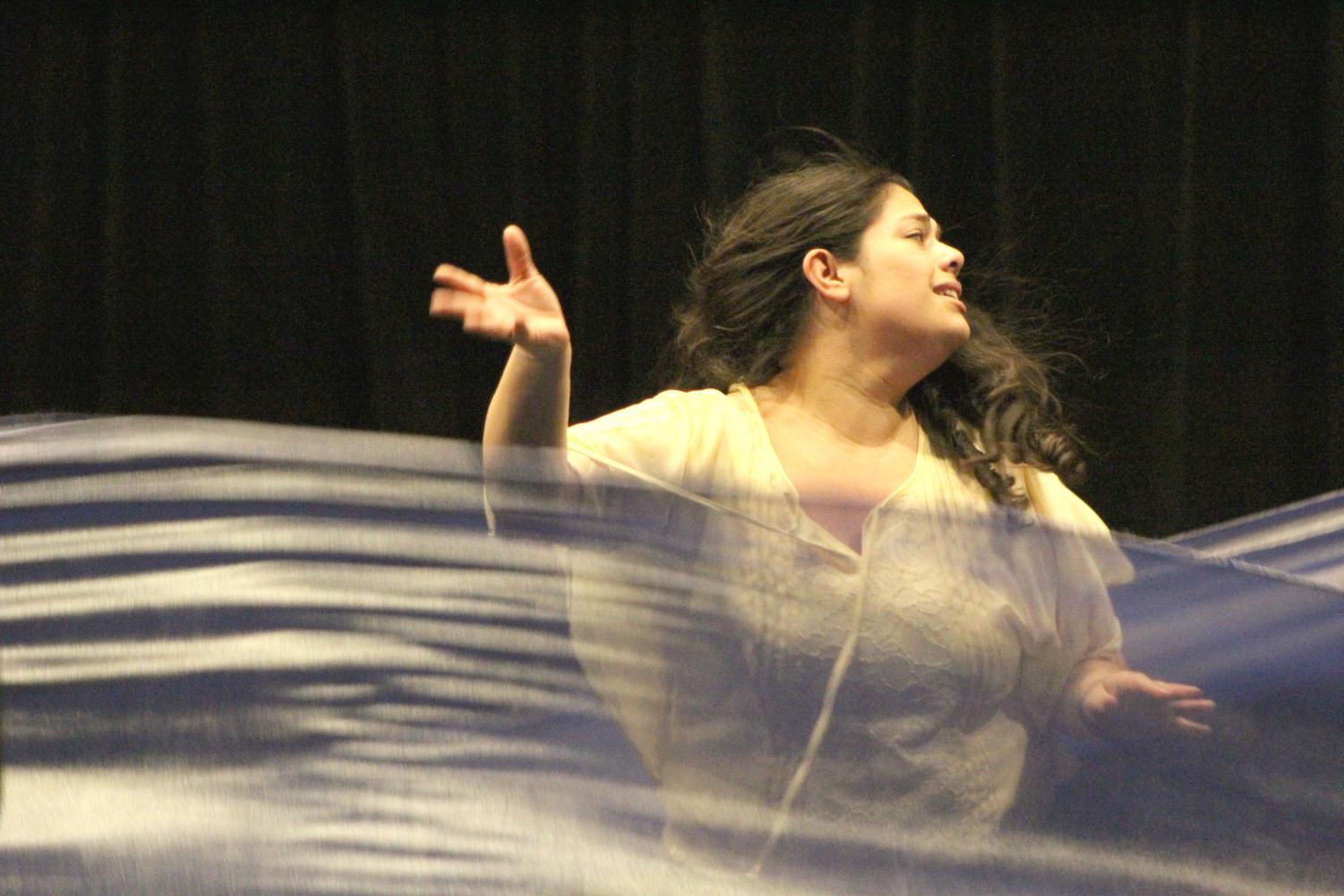 Xochiti, played by Stephanie Rivas, acts as she were being drowned with ribbons that signify water during a Monday rehearsal for