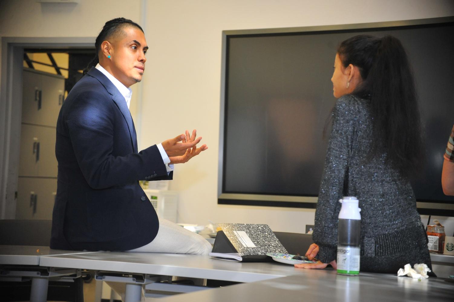 Contra Costa College alumnus Edwin Reyes (left) talks to physics major Ruth Elizabeth Whet (right) in the Physical Sciences Building after his Friday seminar.