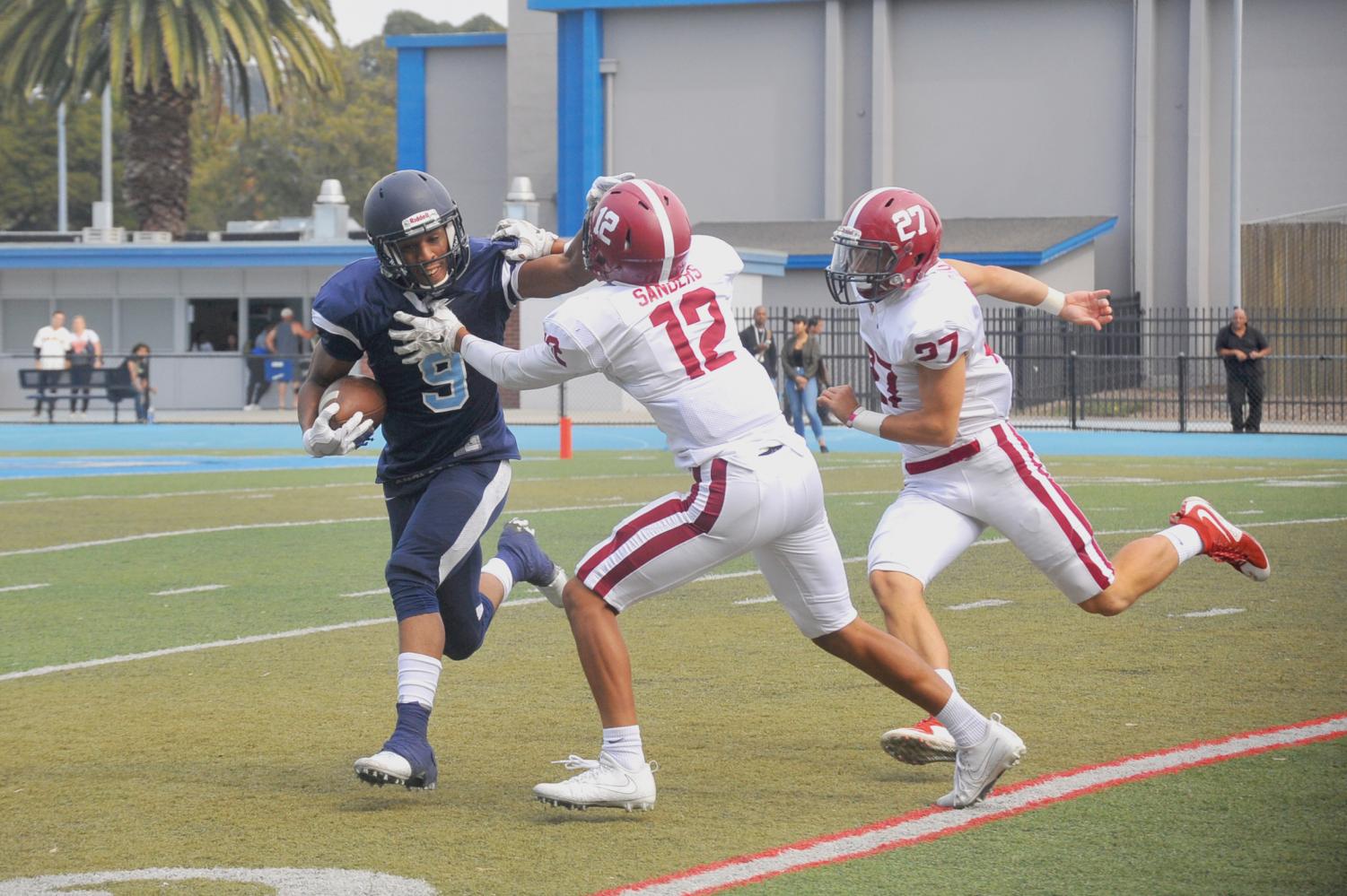 Comet wide receiver Courtney Beane (left) stiff arms Wolverine defensive back Dominick Sanders (middle) during Sierra College’s 56-28 win against Contra Costa College on Sept. 9 at Comet Stadium.